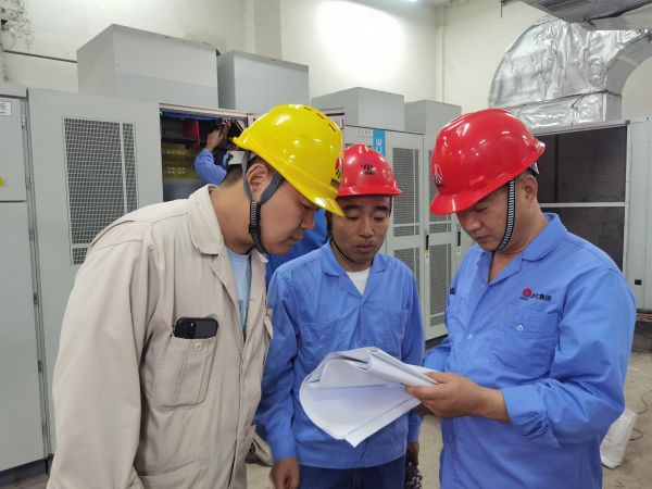 312變頻器室，專項小組正在分析圖紙對新變頻器進行調試.jpg
