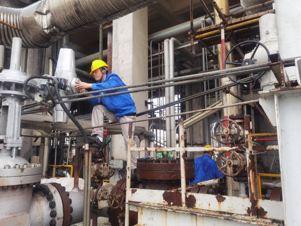 氣化爐上，柳曦、徐騰飛冒雨調試氣化爐電動閥.jpg